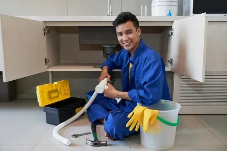 Plumber fixing kitchen sink drain